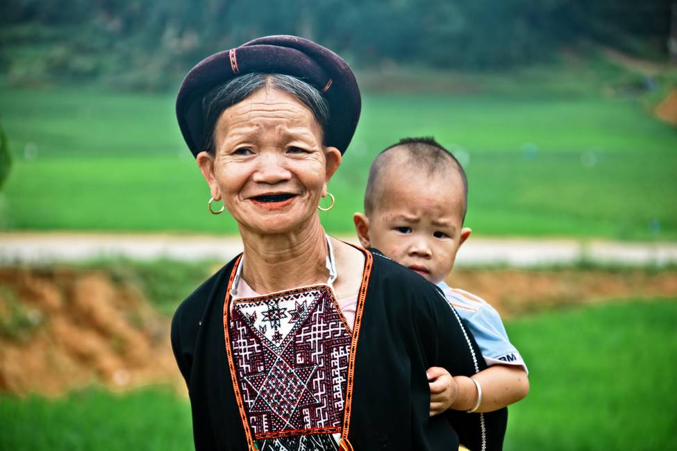 Femme aux dents laquées de l'ethnie Dao au pantalon blanc dans le nord Vietnam